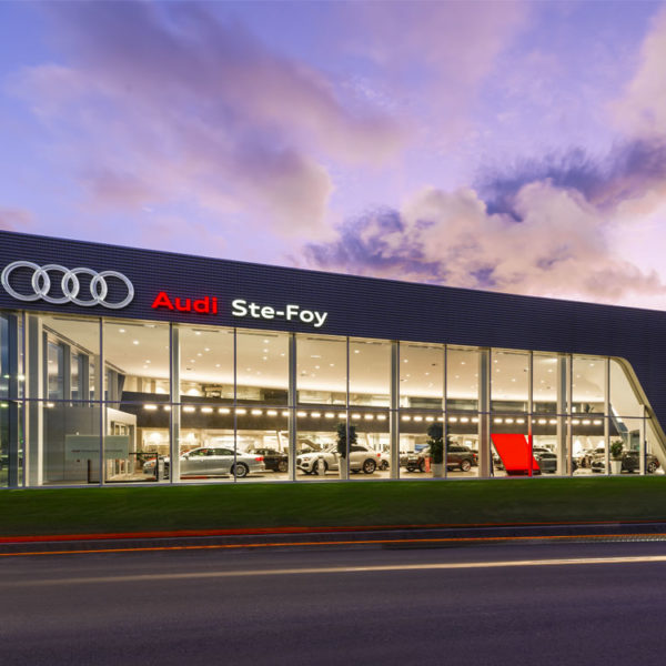 Bâtisse Audi Ste-Foy sous ciel coloré en soirée avec luminaires extérieurs