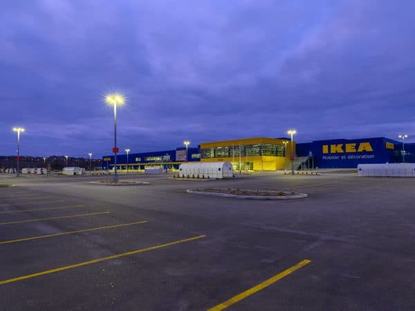 Bâtisse IKEA sous ciel sombre en soirée avec luminaires extérieurs
